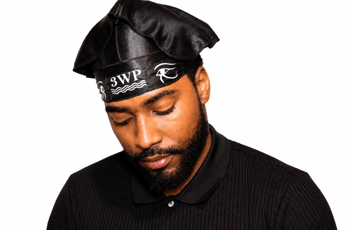 A man wearing a black satin-like beret-style hat with a black headband featuring white '3WP' lettering and a stylized 'Wave' logo, paired with a black ribbed polo shirt, against a plain white background.